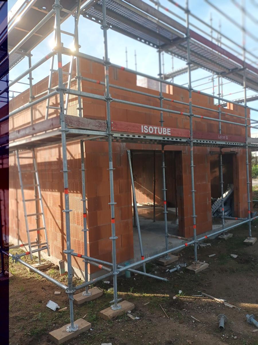 Construction neuve en briques rouges avec échafaudage